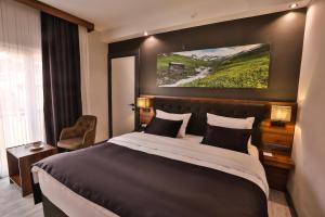 una habitación de hotel con una cama y un cuadro en la pared en Azra Suite Otel en Trebisonda