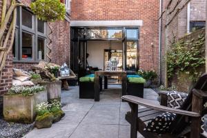 a patio with benches and a table in a brick building at Het Zeeuwse Bloemenhuis in IJzendijke