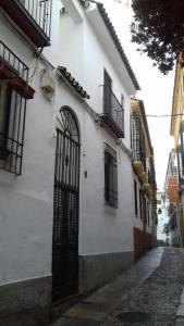 een wit gebouw met een poort op een straat bij PATIO POMPEYOS in Córdoba +51 foto's