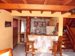 cocina con encimera con sillas y nevera en Mont Blanc Bungalows en San Carlos de Bariloche