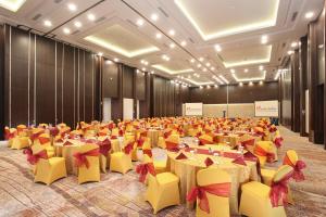 une grande salle de banquet avec des tables et des chaises jaunes dans l'établissement Swiss-Belinn Modern Cikande, à Serang