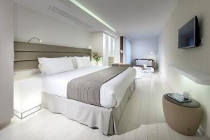a hotel room with a large bed and a television at Eurostars Book Hotel in Munich