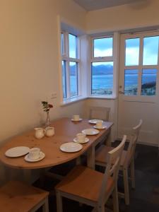 a dining room with a table and chairs and windows at B&B Sólheimar 9 in Akureyri