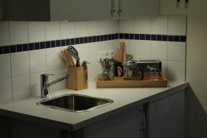 a kitchen counter with a sink and utensils at B&B Sólheimar 9 in Akureyri