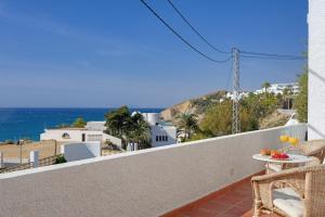balcón con mesa, sillas y vistas al océano en Buccara Villa Levante en Villajoyosa
