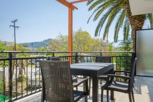 a patio with a table and chairs on a balcony at Palm Studios in Limenas