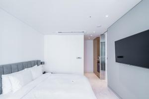 a bedroom with a bed and a flat screen tv at Patio 7 in Seoul