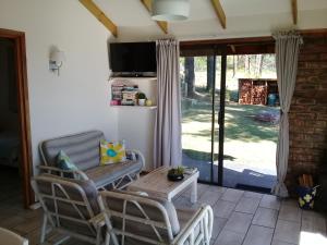 a living room with a table and chairs and a sliding glass door at Wild fig Cottage in Sedgefield