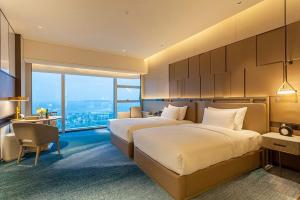 Postel nebo postele na pokoji v ubytování Tianyuan Grand Hotel Xiamen + 37 fotografií