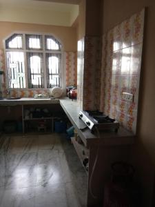 a kitchen with a counter and two windows at Apurba's Pensione in Guwahati