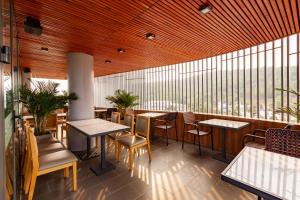 a restaurant with tables and chairs and a large window at An Phu Hotel in Phu Quoc