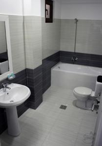 a bathroom with a sink and a toilet and a bath tub at KorcaSmileHotel in Korçë