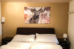 a bedroom with a picture of a deer on the wall at Chalet Windegg - CharmingStay in Flumserberg