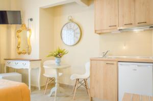 a kitchen with a table and a clock on the wall at Palm Studios in Limenas +39 photos