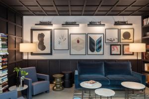 a living room with a blue couch and pictures on the wall at Yurbban Ramblas Boutique Hotel in Barcelona