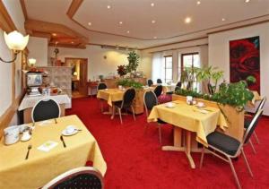 ein Restaurant mit Tischen und Stühlen und einem roten Teppich in der Unterkunft Hotel Restaurant Adler in Westhausen