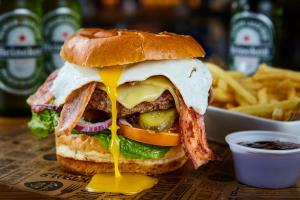 a sandwich with cheese and meat and french fries at St Christopher's Greenwich in London