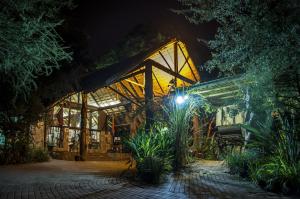a greenhouse at night with a lit up building at Kedar Heritage Lodge, Conference Centre & Spa in Phokeng