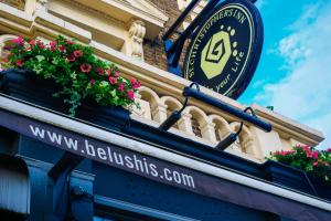 a sign on the side of a building with flowers at St Christopher's Inn Greenwich in London +9 photos