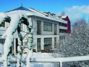 a house covered in snow in front at Familienhotel Reiterhof Runding in Runding