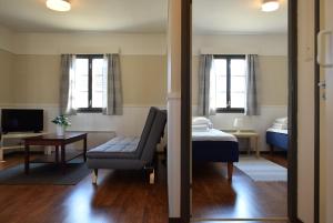 a living room with a bed and a chair and a couch at Visulahti Cottages in Mikkeli