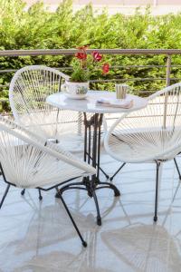 a white table and two chairs on a patio at John Apartments in Dhrepanon