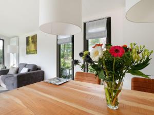 a vase of flowers sitting on a wooden table at Wellness Forest Retreat in Markelo +32 photos