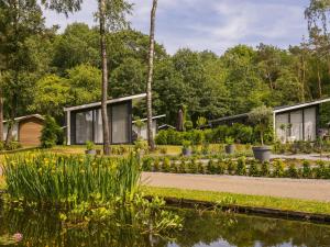 a house in a garden with a pond at Wellness Forest Retreat in Markelo