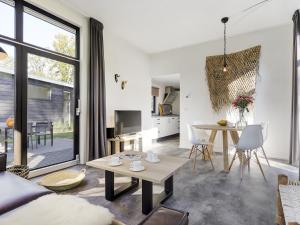 een woonkamer met een bank en een tafel bij Relaxing Forest Hideaway in Markelo