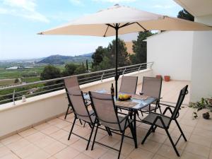 a table and chairs with an umbrella on a balcony at Monte Corona in Ador