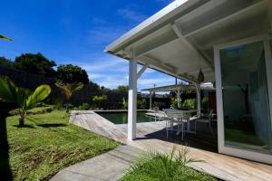 a pavilion with a table and chairs next to a pool at Kaza Blanka - Kaze Tropicale***** - Saint Leu - Réunion in Saint-Leu