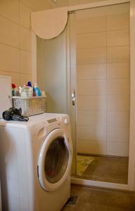 a washing machine in a bathroom with a door at Apartman Aurora in Poreč