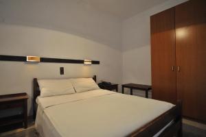 a bedroom with a bed and a wooden cabinet at El Greco in Igoumenitsa