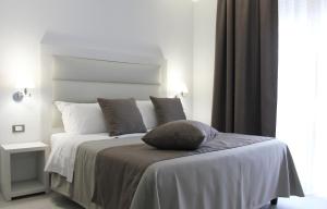 a white bed with a pillow on top of it at Park Hotel Giusy in Lido di Camaiore