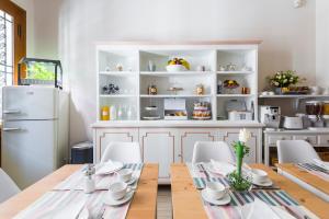 Un comedor con una mesa y un refrigerador. en Villa Savioli Room & Breakfast, en Bolonia