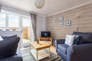 uma sala de estar com dois sofás e uma televisão em Solstice em Poole