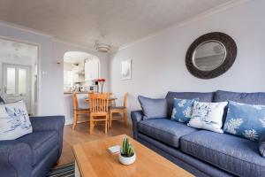 uma sala de estar com um sofá azul e uma mesa em Solstice em Poole