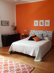 a bedroom with a bed with an orange wall at B&B DUE ABETI in Florence