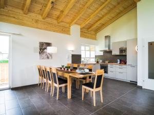 a kitchen with a wooden table and chairs at AlpenParks Chalet & Apartment AreitXpress in Zell am See