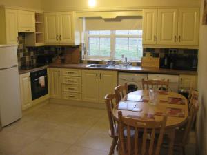 a kitchen with a table and chairs and a kitchen with yellow cabinets at Willies cottage in Donegal