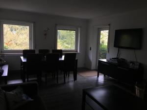 a dining room with a table and chairs and two windows at Sauerland vakantiehuisje in Diemelsee