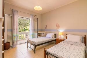 a bedroom with two beds and a window at The Olive Grove Cottage by Konnect - 2,5km from Ipsos in Ýpsos