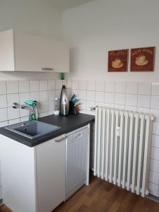 een keuken met een wastafel en een radiator bij Neues, ruhiges Apartment Nordic in Düsseldorf-Nord in Düsseldorf