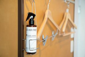 a bottle of air freshener hanging on a door at Hotel Wing International Tokyo Akabane in Tokyo