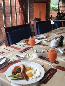 Asante Guest House في فاندربيجلبارك: طاولة مع أطباق من الطعام وكؤوس من عصير البرتقال