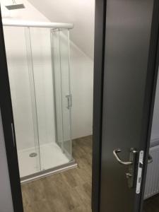 Una puerta de ducha de cristal en una habitación con en Kimanoclegi, en Opole