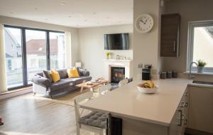 a kitchen and living room with a couch and a table at Southbourne Luxury Ocean Villa in Bournemouth