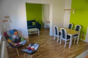 sala de estar con mesa, sillas y sofá en Puzzle Apartment en Dedinje