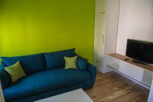 a living room with a blue couch and a green wall at Puzzle Apartment in Dedinje