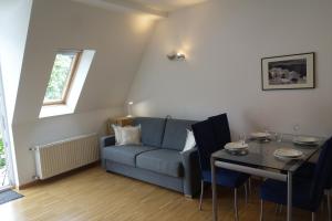 Hager Apartment 2 في ميرانو: غرفة معيشة مع أريكة زرقاء وطاولة